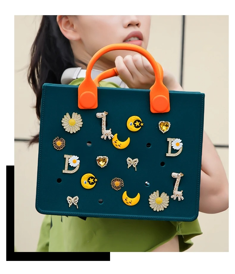 Borsa eva verde scuro con manici arancioni e charms gialli di sole, luna, margherite e giraffa