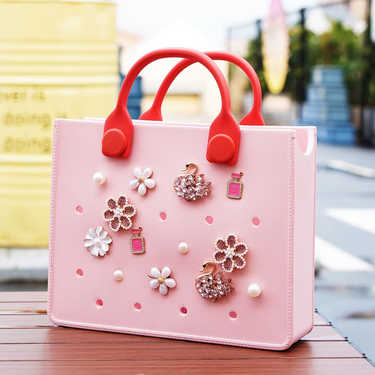 borsa in gomma eva rosa con manici rossi e charms attaccati di perle e fiori